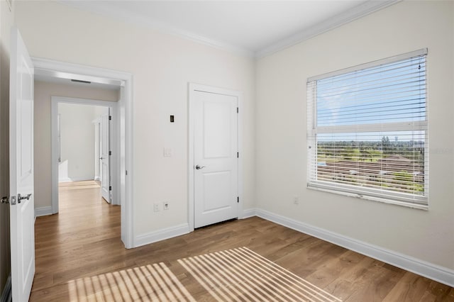 unfurnished bedroom featuring wood-type flooring and ornamental molding