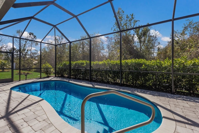 view of pool with a patio and glass enclosure