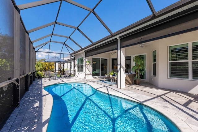 view of swimming pool featuring a patio area, ceiling fan, and glass enclosure