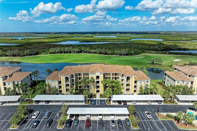 drone / aerial view with a water view and golf course view