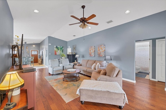 living room with ceiling fan, dark hardwood / wood-style floors, vaulted ceiling, and a wealth of natural light