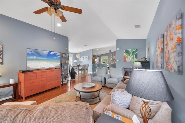 living room with lofted ceiling, hardwood / wood-style floors, and ceiling fan