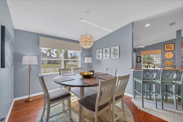 dining room with hardwood / wood-style flooring and lofted ceiling