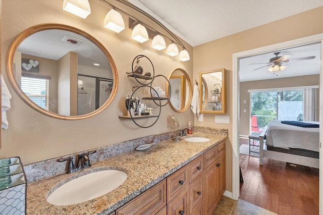 bathroom featuring vanity, hardwood / wood-style floors, a textured ceiling, and ceiling fan