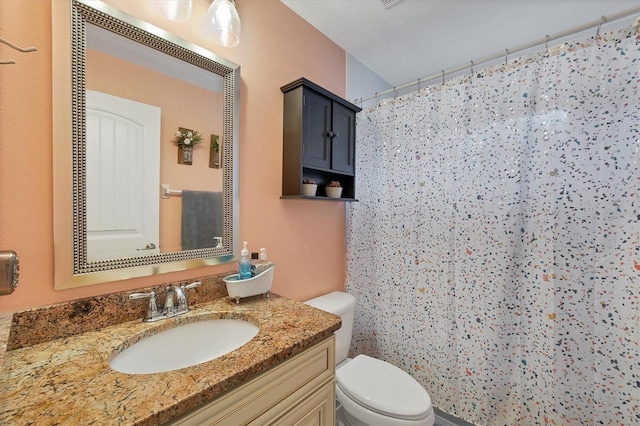 bathroom with walk in shower, vanity, and toilet