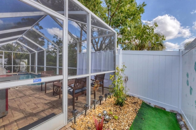 view of swimming pool with glass enclosure and a patio area