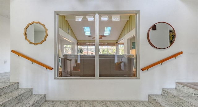 stairway with vaulted ceiling with skylight