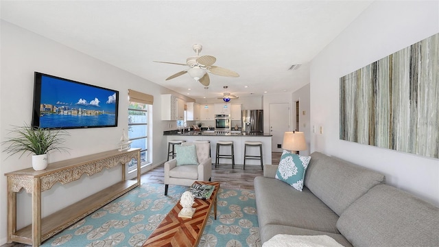 living room featuring light hardwood / wood-style flooring and ceiling fan