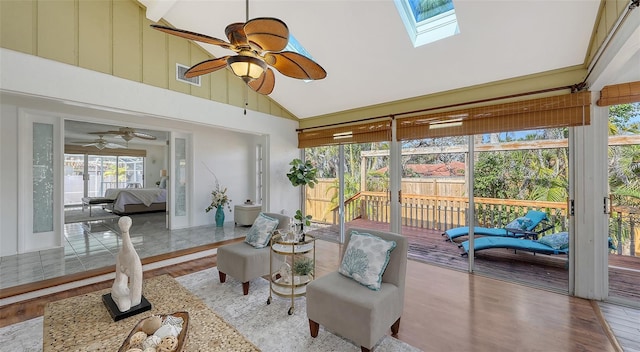 sunroom / solarium with ceiling fan and vaulted ceiling with skylight