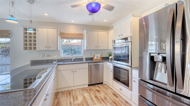 kitchen with appliances with stainless steel finishes, decorative light fixtures, sink, and white cabinets