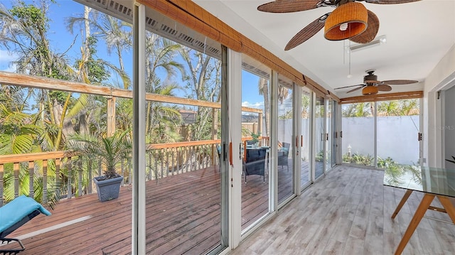 unfurnished sunroom with ceiling fan