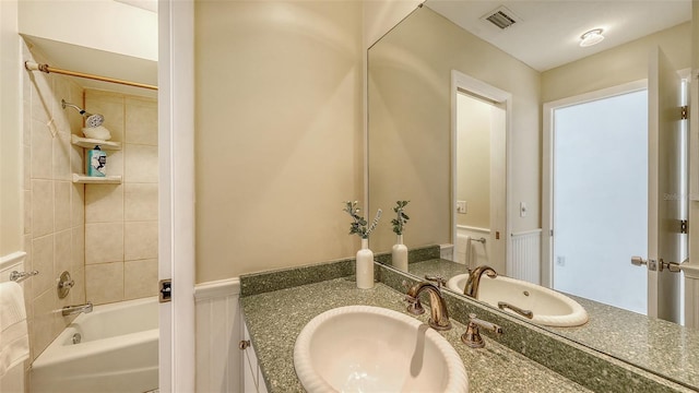 bathroom with vanity and tiled shower / bath combo