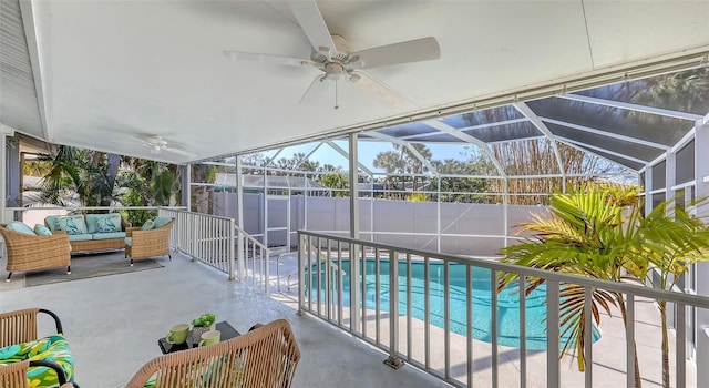 view of pool with an outdoor living space, a patio, ceiling fan, and glass enclosure