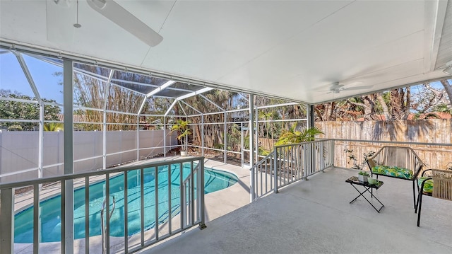 view of pool with a patio area, ceiling fan, and glass enclosure