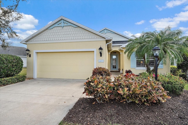 view of front of property with a garage, driveway, and stucco siding