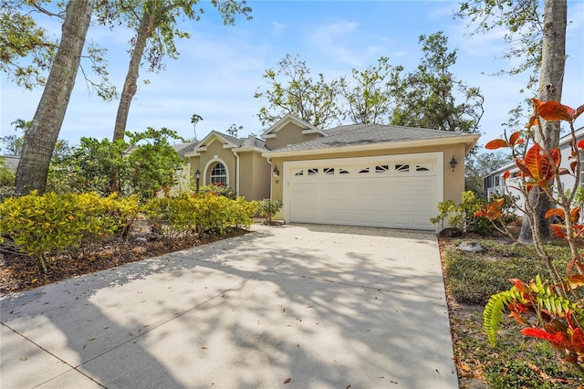 view of front of property with an attached garage, a shingled roof, concrete driveway, and stucco siding