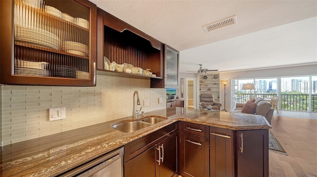 kitchen with a textured ceiling, light stone countertops, ceiling fan, backsplash, and sink