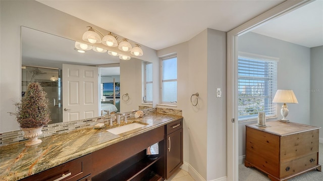 bathroom with a shower with door, vanity, and tasteful backsplash