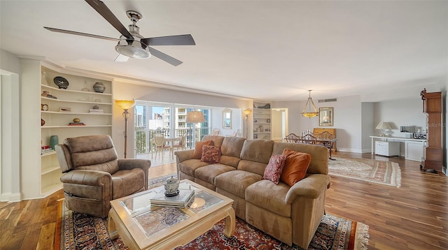 living room with hardwood / wood-style floors, ceiling fan, and built in shelves