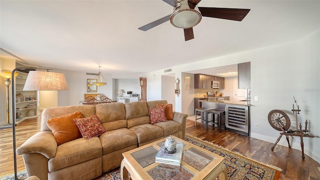 living room featuring wine cooler, ceiling fan, and dark wood-type flooring