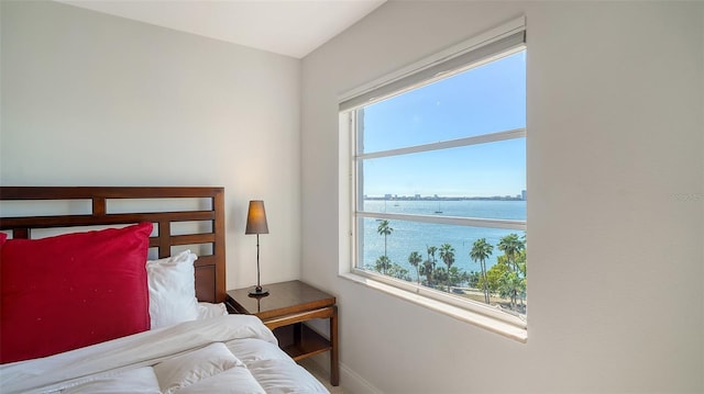 bedroom with multiple windows and a water view