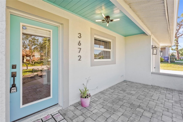 entrance to property with covered porch and ceiling fan