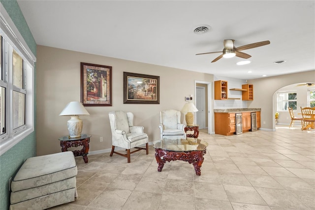 living area with light tile patterned floors, ceiling fan, and beverage cooler