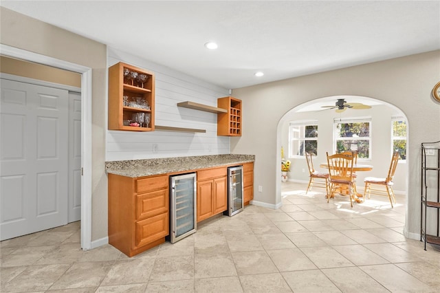 kitchen featuring wine cooler, light tile patterned floors, and light stone countertops