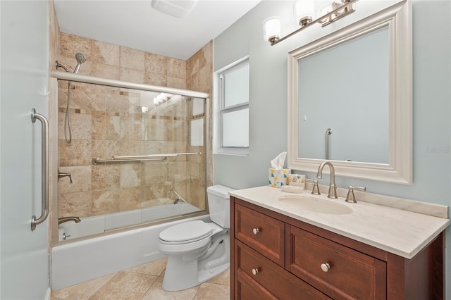 full bathroom with tile patterned flooring, bath / shower combo with glass door, vanity, and toilet