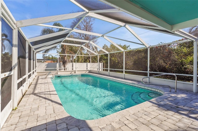 view of swimming pool featuring glass enclosure and a patio area