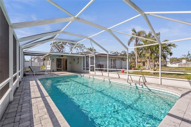 view of pool with ceiling fan, a patio, and a lanai