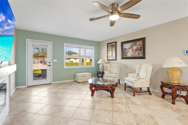 living area featuring ceiling fan, tile patterned flooring, and baseboards