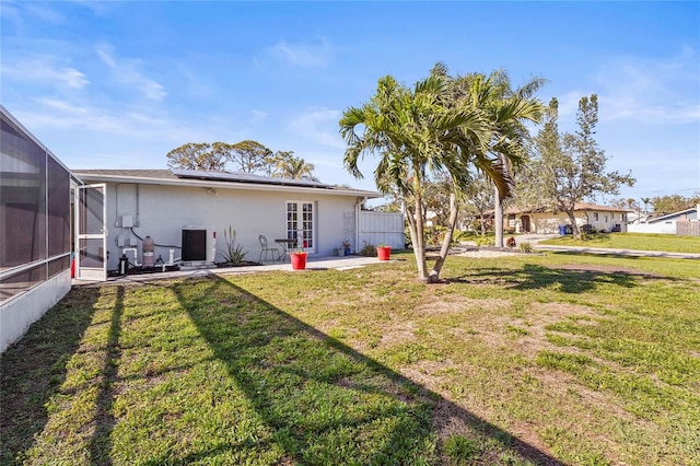 view of yard with a patio, french doors, cooling unit, and a lanai