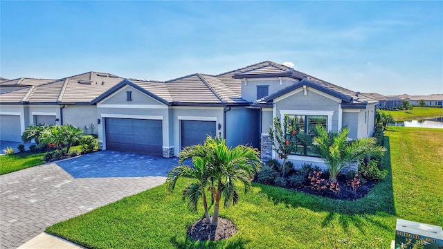 single story home with a garage, a water view, and a front yard