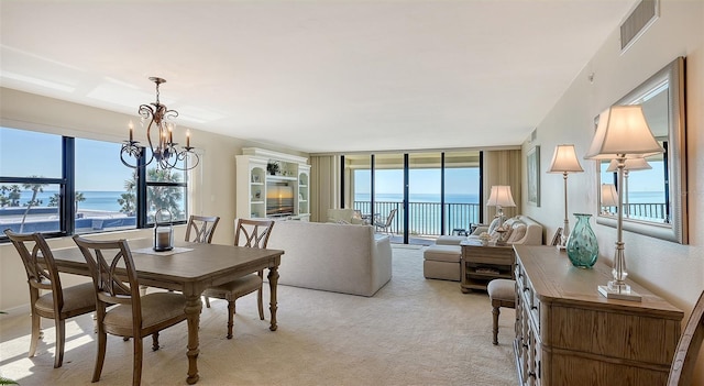 carpeted dining space featuring an inviting chandelier and expansive windows