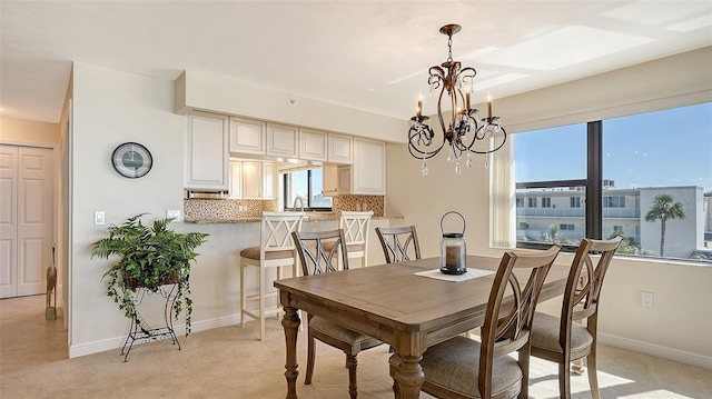 dining space featuring light colored carpet and a chandelier