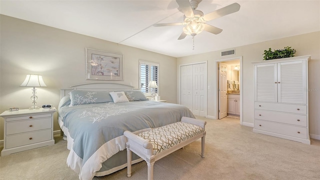 carpeted bedroom featuring ensuite bathroom, ceiling fan, and a closet