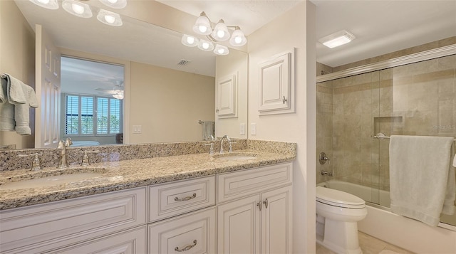 full bathroom featuring toilet, ceiling fan, vanity, and bath / shower combo with glass door