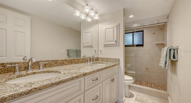 bathroom featuring vanity, a shower with shower door, tile patterned floors, and toilet