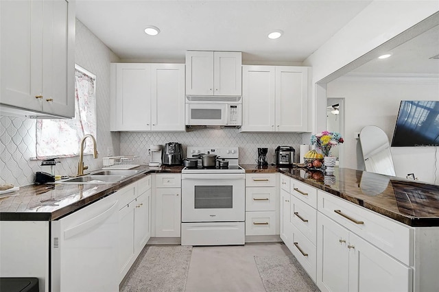 kitchen featuring tasteful backsplash, white appliances, sink, white cabinetry, and kitchen peninsula