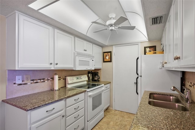 kitchen featuring tasteful backsplash, visible vents, white cabinetry, a sink, and white appliances