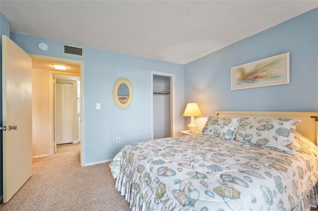 bedroom with a textured ceiling, carpet flooring, visible vents, baseboards, and a closet