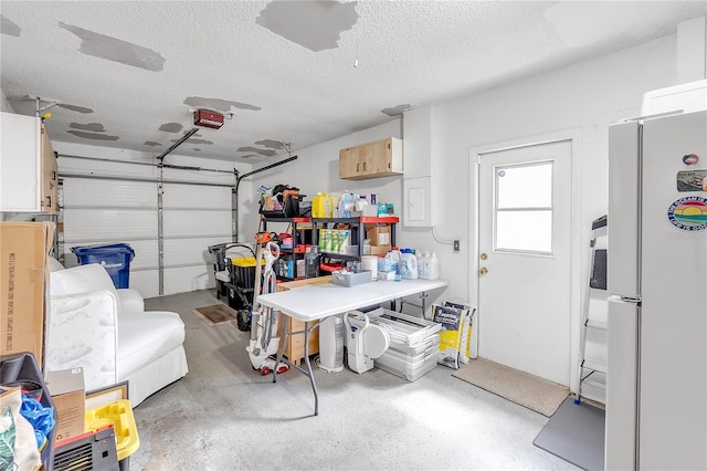 garage with white refrigerator and a garage door opener