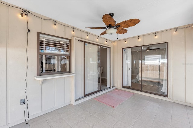 view of exterior entry with ceiling fan and a patio area