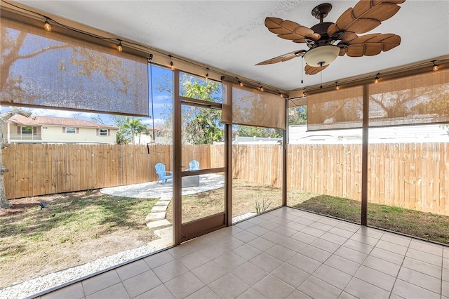 unfurnished sunroom featuring ceiling fan