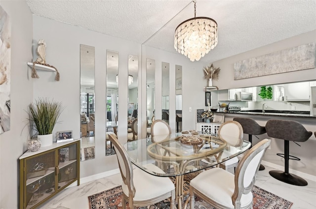 1515 Forrest Nelson Blvd Unit Q205, Port Charlotte, FL 33952 - dining space featuring baseboards, marble finish floor, a textured ceiling, and an inviting chandelier