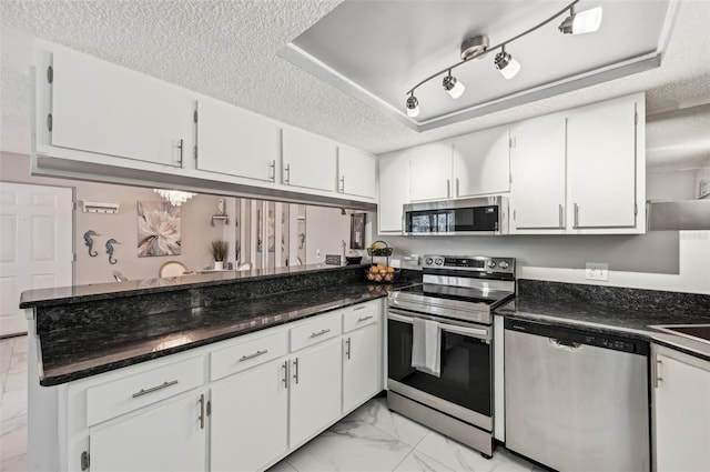 1515 Forrest Nelson Blvd Unit Q205, Port Charlotte, FL 33952 - kitchen with a textured ceiling, marble finish floor, a raised ceiling, a peninsula, and appliances with stainless steel finishes