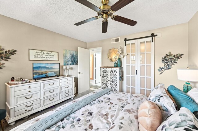 1515 Forrest Nelson Blvd Unit Q205, Port Charlotte, FL 33952 - bedroom featuring a barn door, a textured ceiling, visible vents, and a ceiling fan