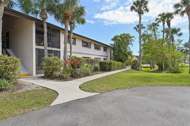 1515 Forrest Nelson Blvd Unit Q205, Port Charlotte, FL 33952 - exterior space with stucco siding, stairs, and a lawn