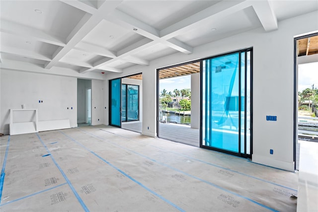 spare room with a water view, coffered ceiling, and beam ceiling